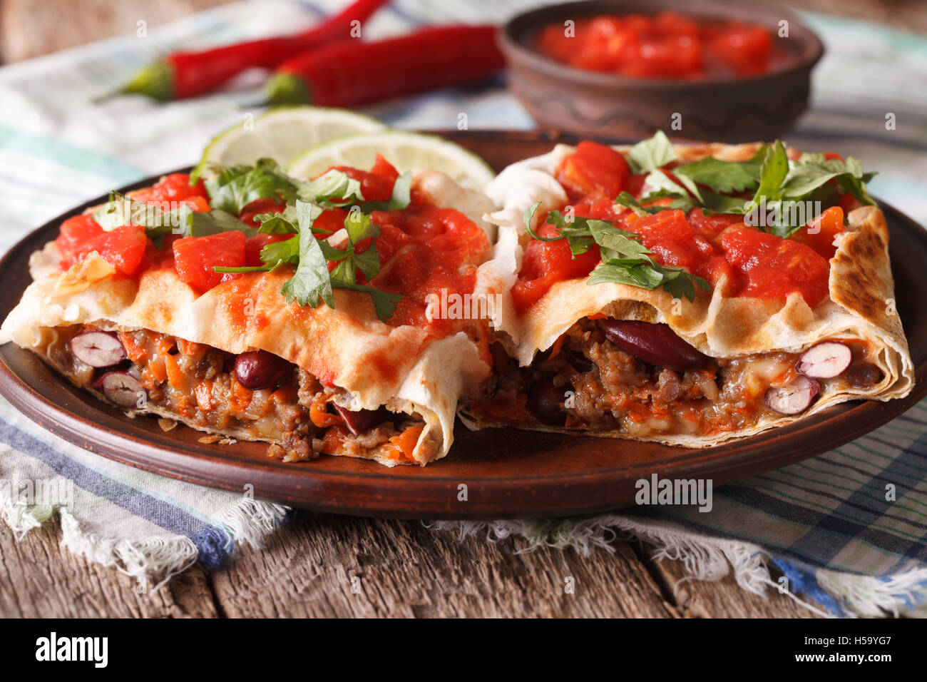 Mexican rolls: chimichanga with tomato salsa on a plate close-up horizontal Stock Photo