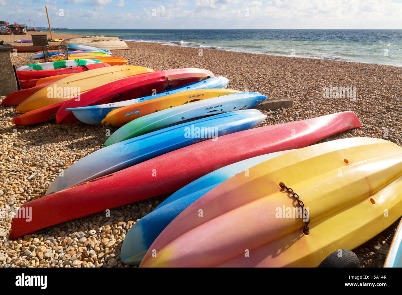 Colourful kayaks on Brighton beach, Brighton, Sussex UK Stock Photo