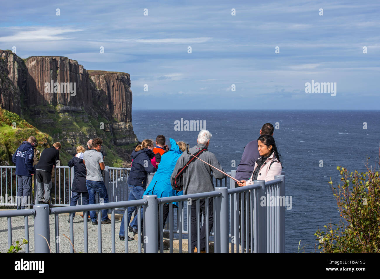 Tourists at viewpoint looking at Mealt waterfall at Kilt Rock, sea cliff on the Isle of Skye, Trotternish, Highlands, Scotland Stock Photo