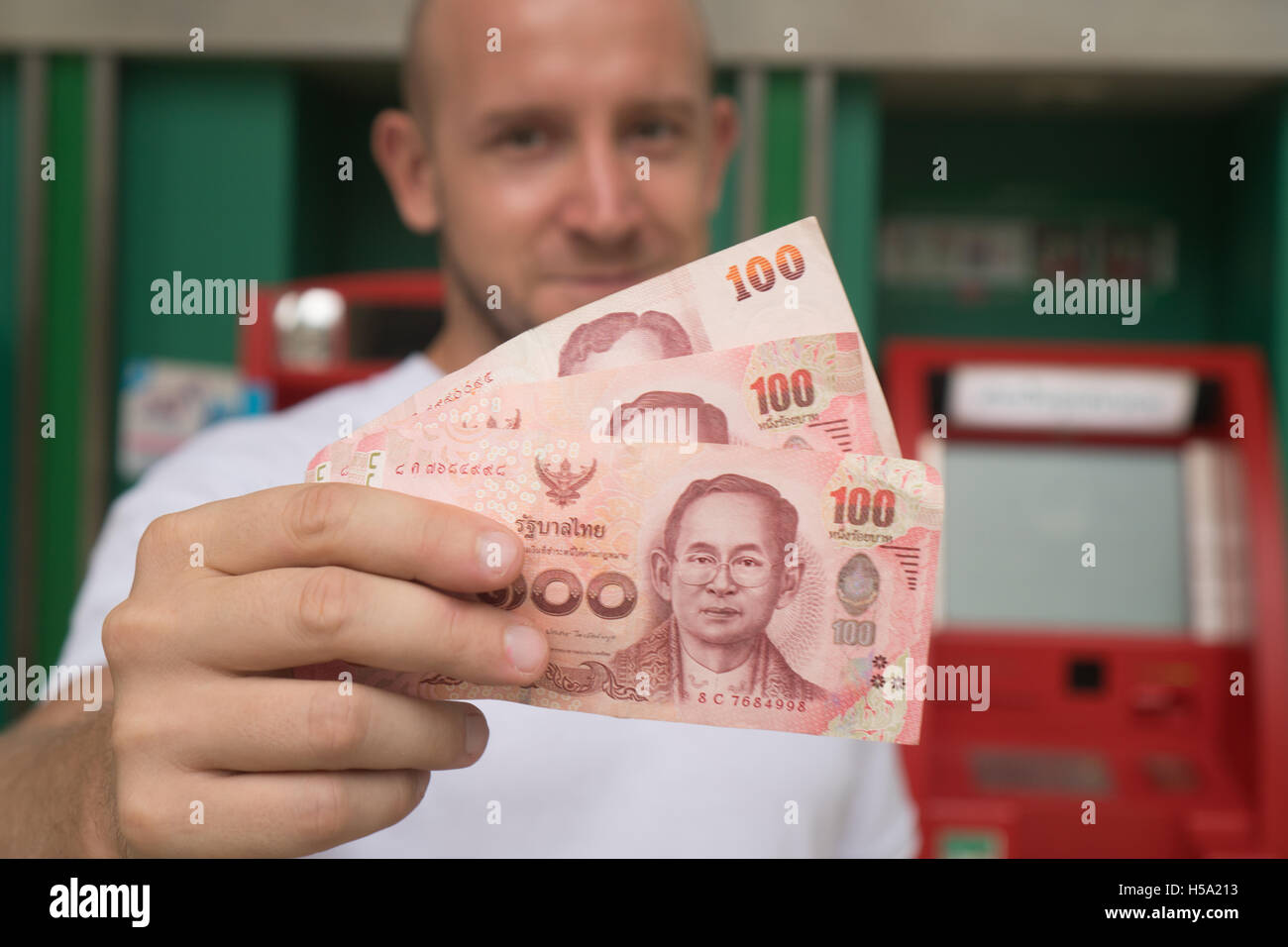 Closeup Of 100 Thai Baht Notes Withdrawn From Atm Over Blurred