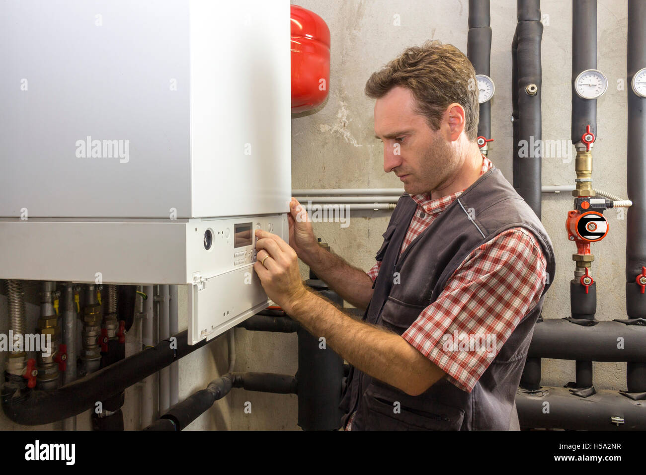 plumber who carries out the maintenance of a condensing boiler Stock Photo