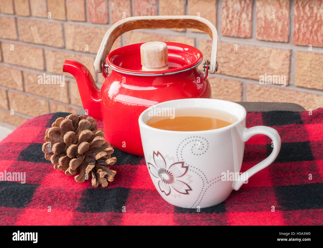 Tea in teacup with kettle on winter throw with pinecone Stock Photo Alamy