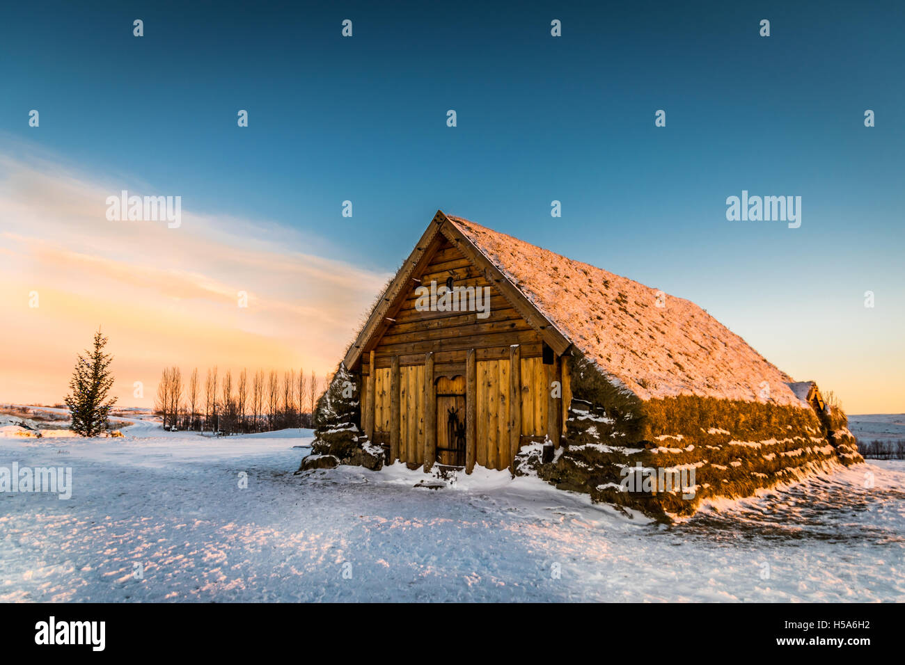 A beautiful small wooden turf church in snow at sunrise next to Skalholt cathedral on the Golden Circle in Southern Iceland Stock Photo