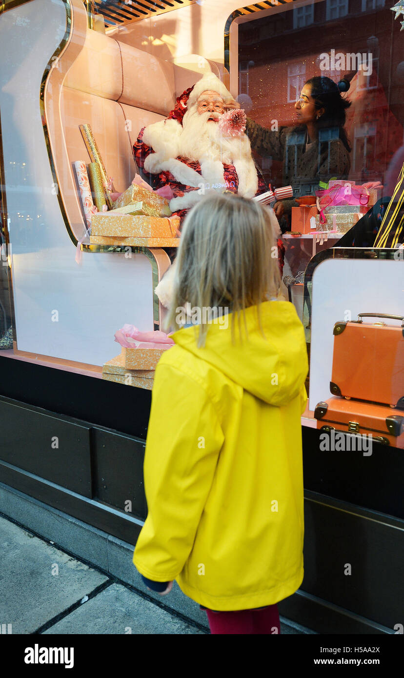 Four year old Erika Bonet looks at one of the Christmas window displays themed as 'Shine on' at Sefridges department store in Oxford Street in central London. Stock Photo