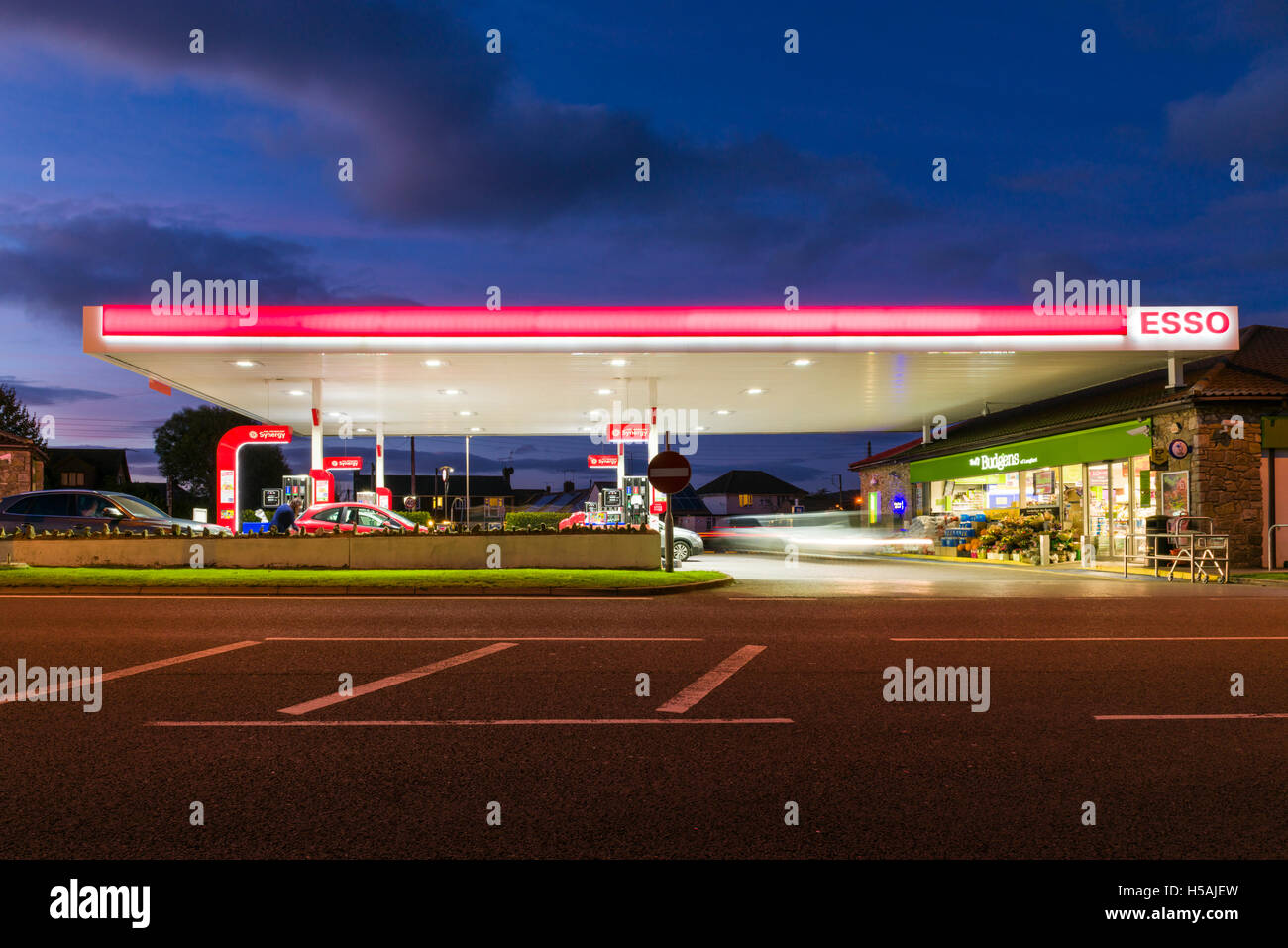 A filling station forecourt lit up at dusk. Stock Photo
