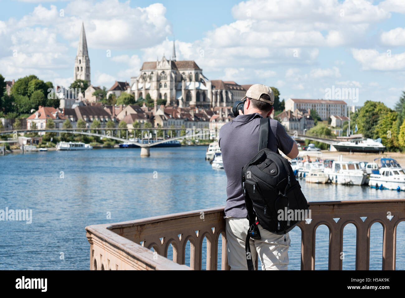 A photographer taking a picture of the Abbaye Saint Germain, Auxerre from the bridge, Pont Paul Bert over river Yonne Stock Photo