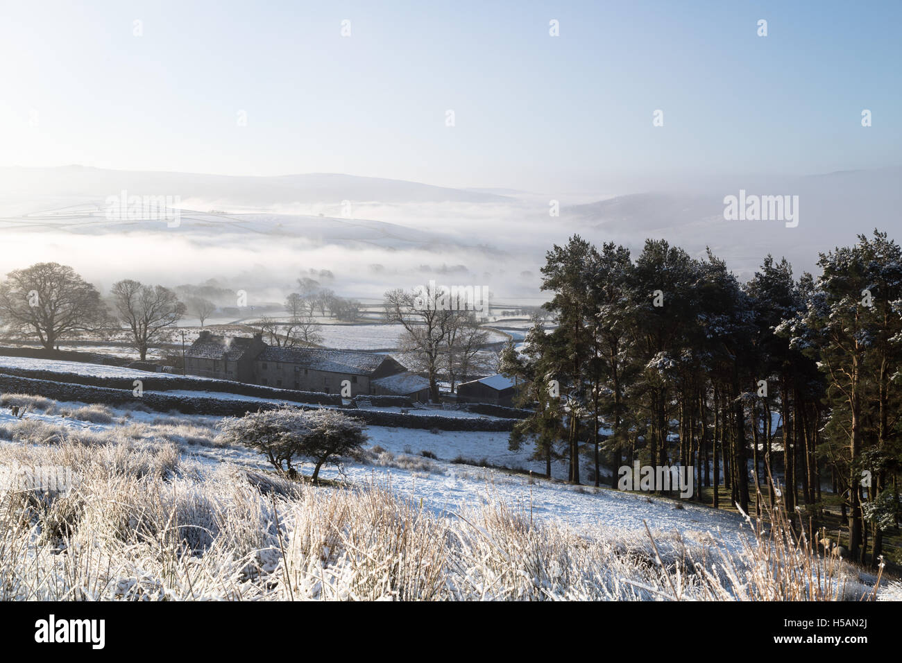 Morning mist rises up Wharfedale after a late winter/early spring overnight snowfall, Yorkshire Dales, England, UK Stock Photo