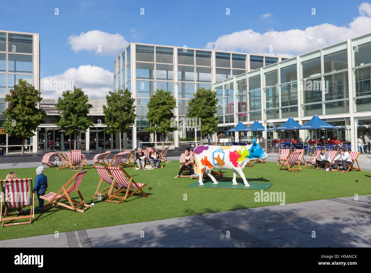 People sitting in deckchairs in the courtyard of Milton Keynes largest shopping centre, MK Centre. Stock Photo