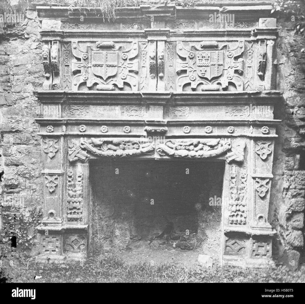 'Carved, stone mantelpiece with crests over the hearth in an