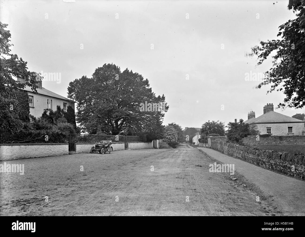 6 Roadway showing motor car parked outside house, Mountmellick, Co. Laois Stock Photo