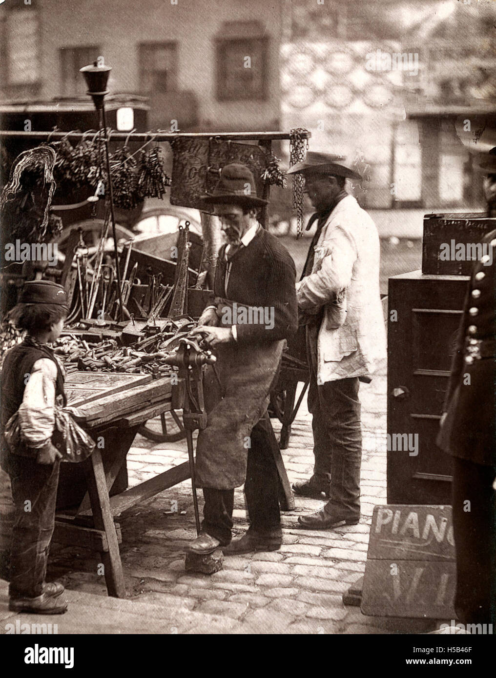 The street locksmith was an essential figure in urban life, offering their services to the community in repairing locks and other metal works, reflecting the daily life of early 20th-century cities. Stock Photo