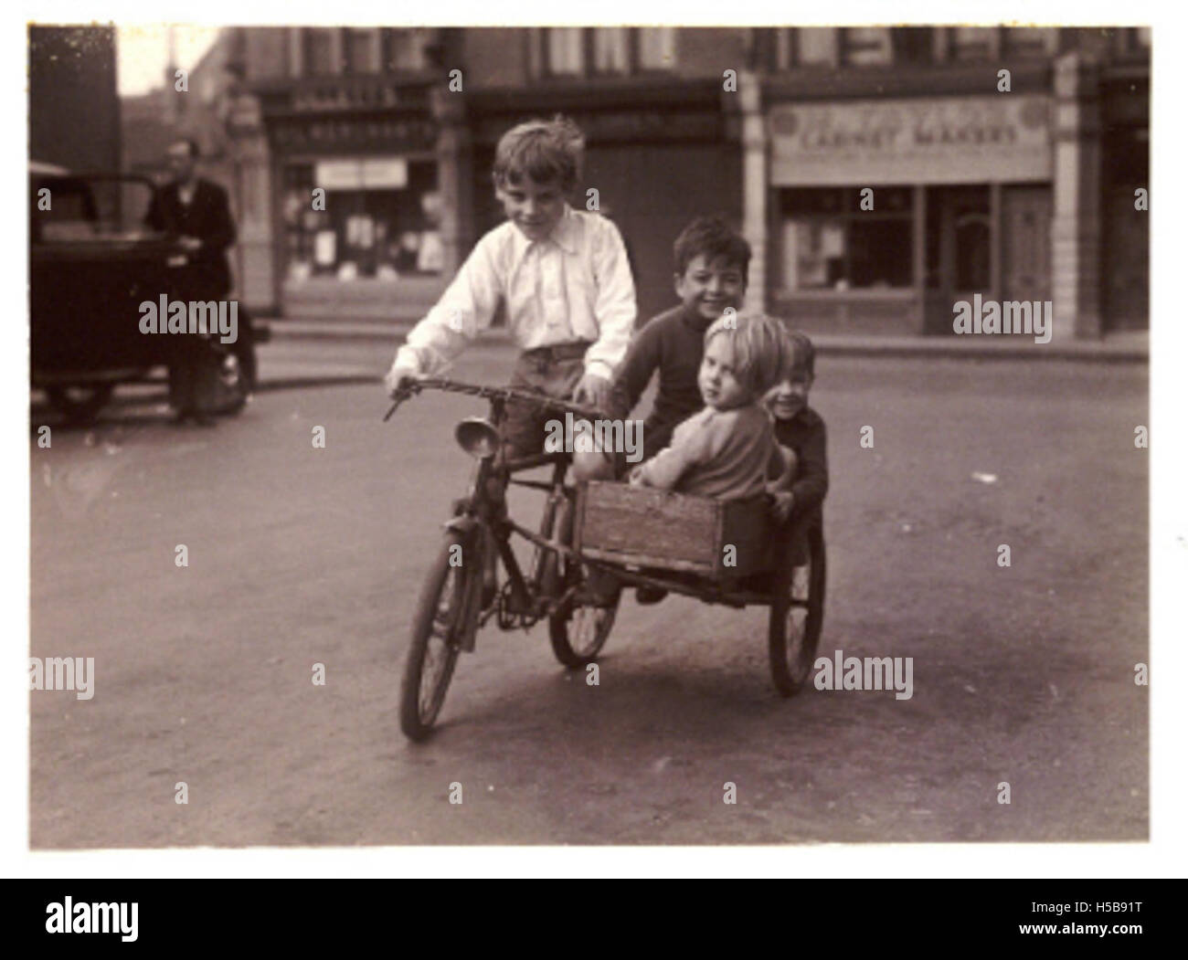 6 Children riding a bicycle and sidecar, about 1930 - 1 Stock Photo