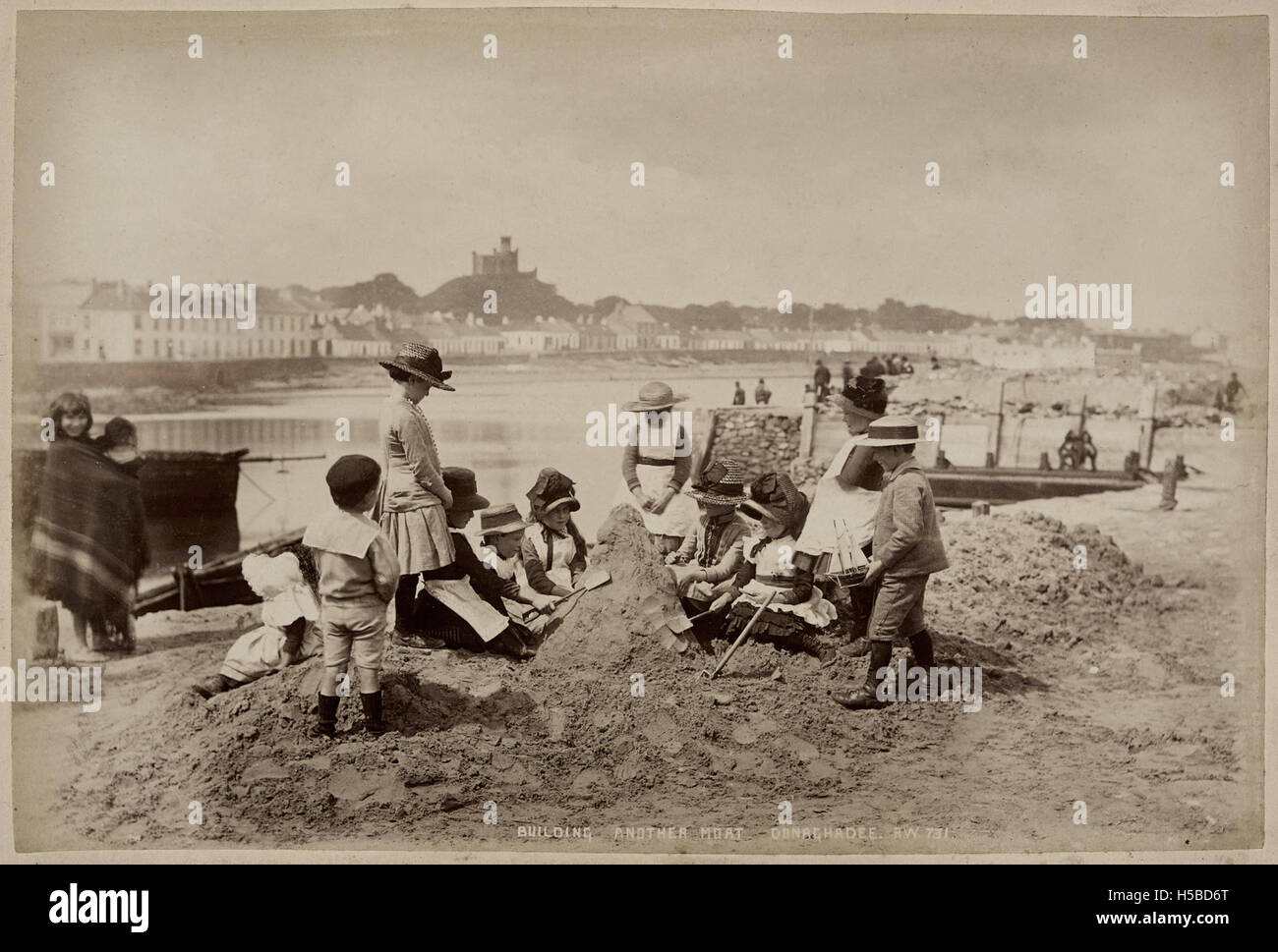 Children building another moat in the sand Stock Photo Alamy