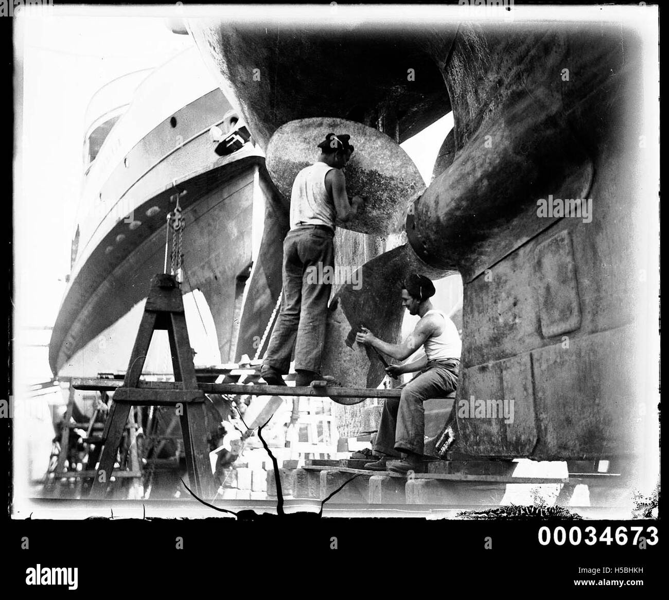 Two sailors cleaning a propeller of the French warship BELLATRIX, 1930-1932 Stock Photo