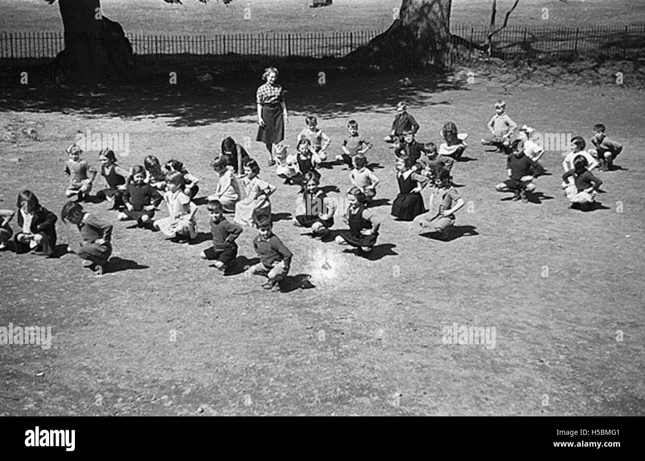 Children are shown participating in physical training activities at Llanfyllin Church School. The photograph highlights the role of physical education in schools during the early 20th century in rural Wales. Stock Photo