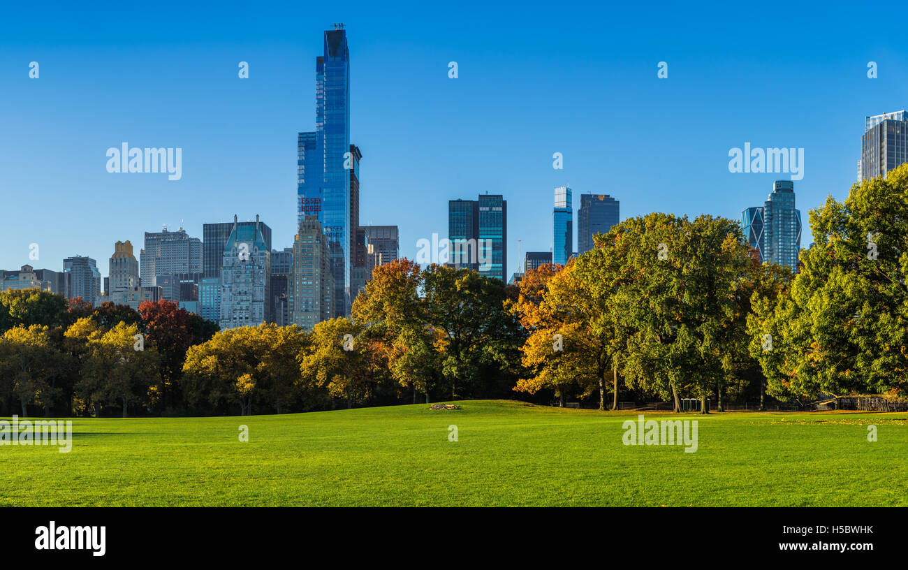 Central Park Sheep Meadow with full autumn colors. Midtown Manhattan skyscrapers in early morning light. New York City Stock Photo