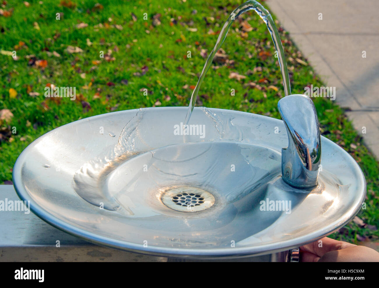 Park water fountain turned on with water flowing down Stock Photo
