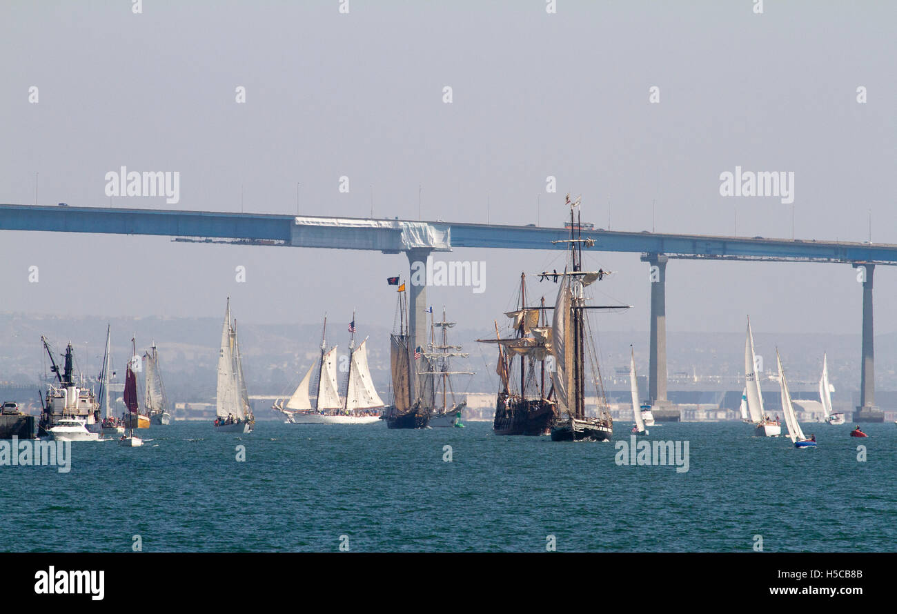 Multiple tall ships during 2016 Festival of Sail, Parade of Ships, San Diego Bay, CA with Coronado Bridge in background Stock Photo