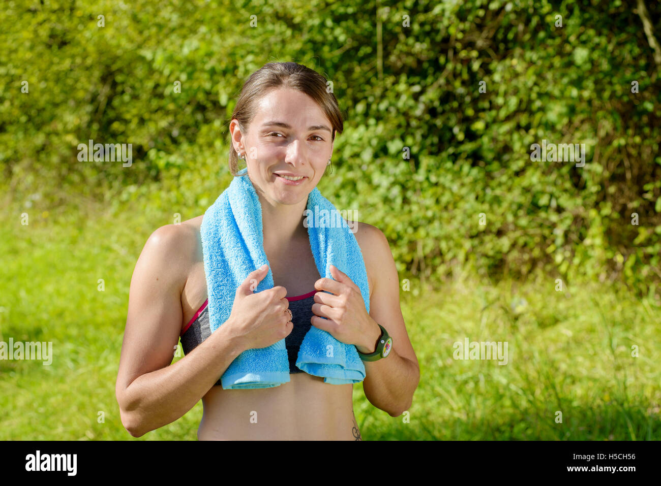 portrait of young sporty woman with blue towel in the countryside Stock ...