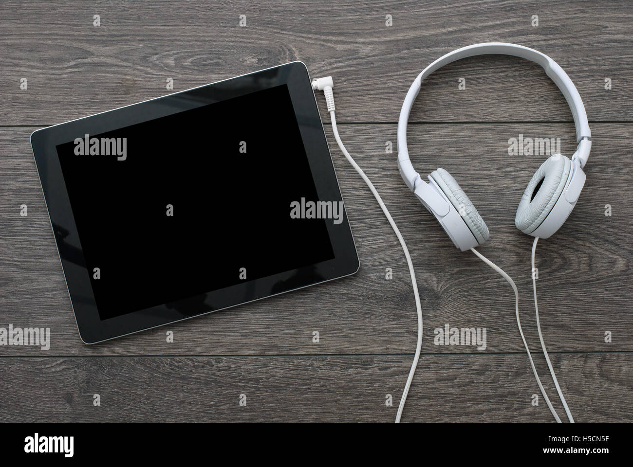 tablet earphones on wooden surface Stock Photo