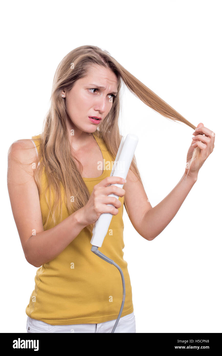 Young woman damage her hair with straightening iron Stock Photo Alamy