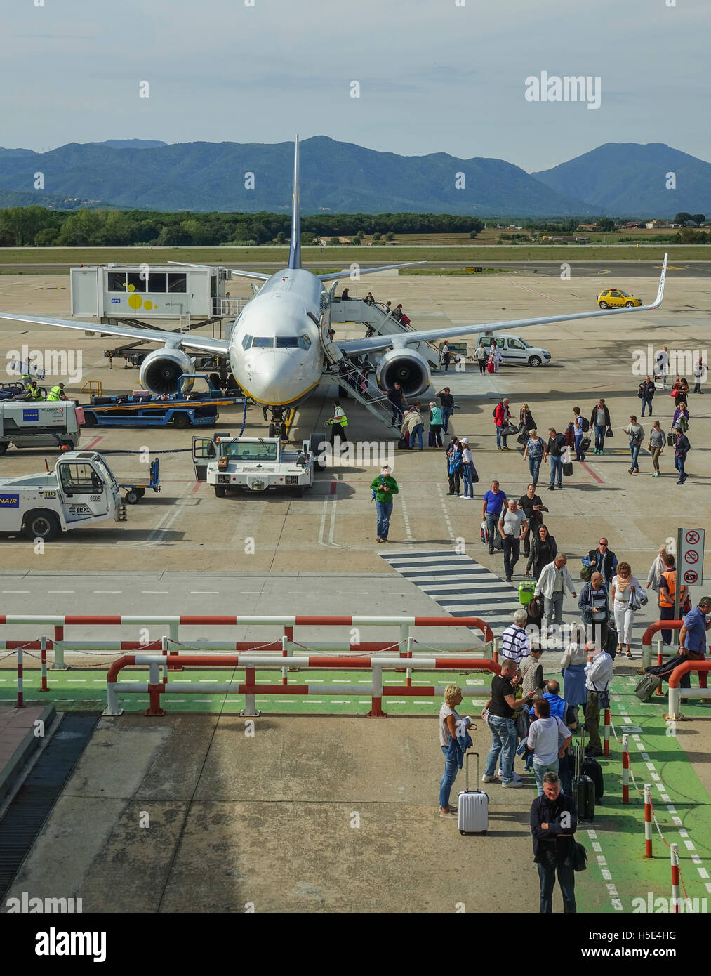 People walking over runway at airport to the arrival terminal Stock Photo