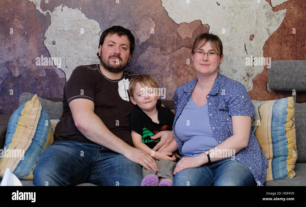 Leipzig, Germany. 19th Oct, 2016. Claudia Menschel, her husband Sven and their three-year-old son Tobias sitting on the coach in their apartment in Leipzig, Germany, 19 October 2016. Menschel and two other mothers sue in front of the Federal Court of Justice (BGH) after not receiving a place for their children in a nursery. The trial is set for this Thursday. Due to the delays, they will not be able to take up their full time jobs after one year of parental leave. PHOTO: SEBASTIAN WILLNOW/dpa/Alamy Live News Stock Photo