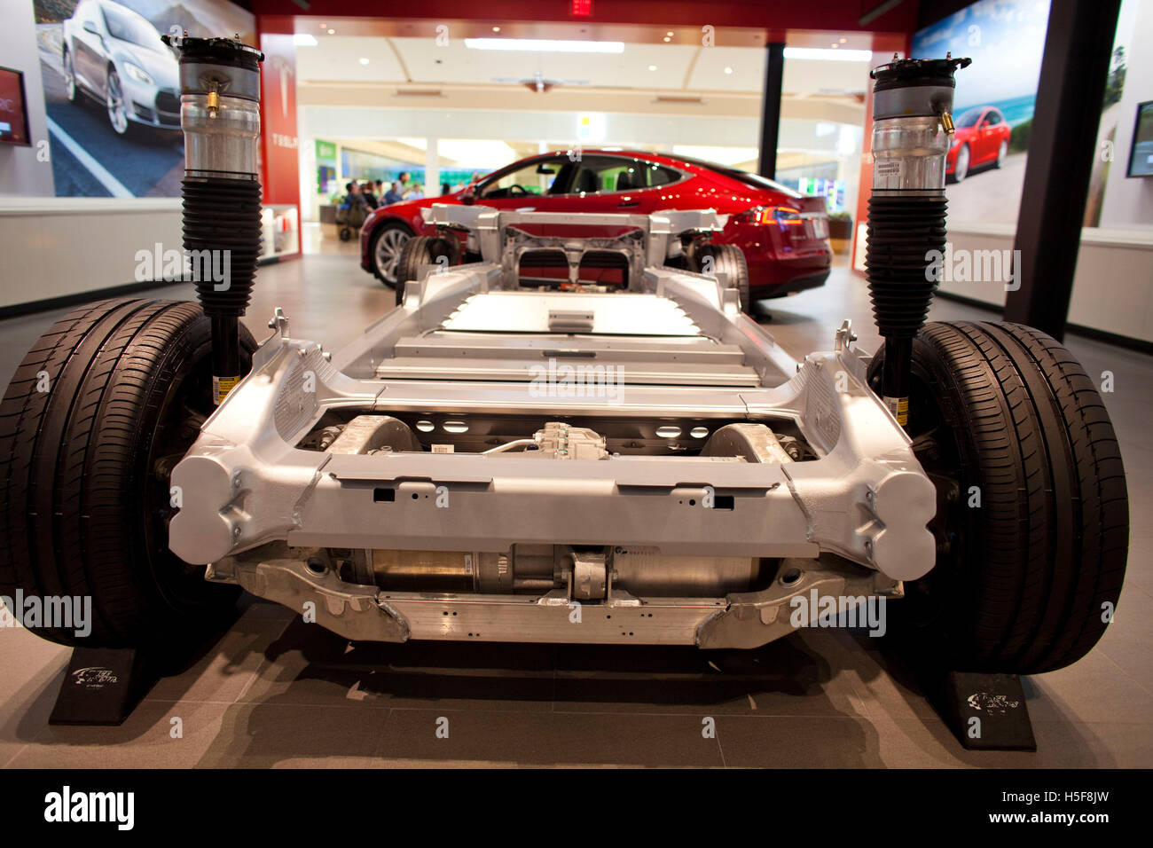 Mission Viejo, California, USA. 18th Mar, 2014. Tesla model S chassis and battery in the Mission Viejo mall showroom. Under a new law, Tesla Motors cannot sell cars directly to consumers in New Jersey effective April 1. Tesla has no existing franchised dealers with which its factory sales compete, and Tesla states that it is selling something so unique that an entirely different sales model is necessary. Currently New Jersey, Arizona, Maryland, Texas and Virginia ban direct sales of Tesla cars to consumers. The bulk of new car sales in the United States go through independently owned dealer Stock Photo