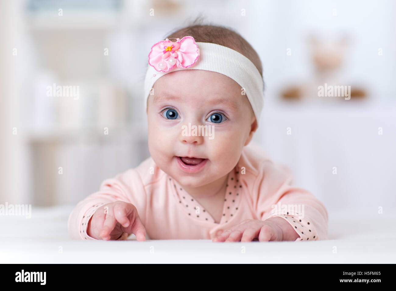 Portrait of pretty baby girl lying on tummy Stock Photo