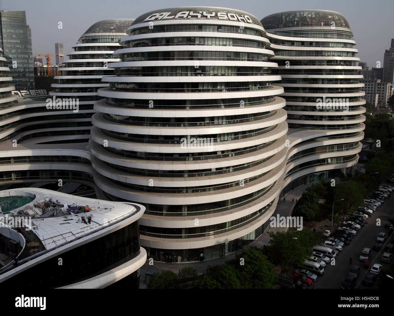 The Galaxy Soho complex of buildings designed by architect Zaha Hadid with repairs being done on the roof of one of the parts. Stock Photo