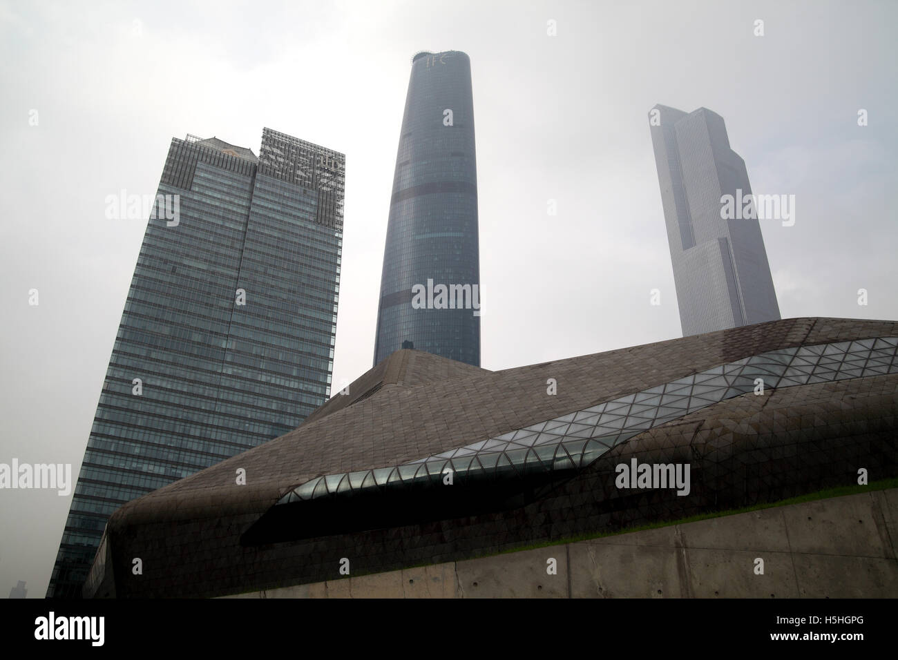 The top part of the Guangzhou Opera House designed by Zaha Hadid and three commercial high rise builldings behind it. Guangzhou. Stock Photo