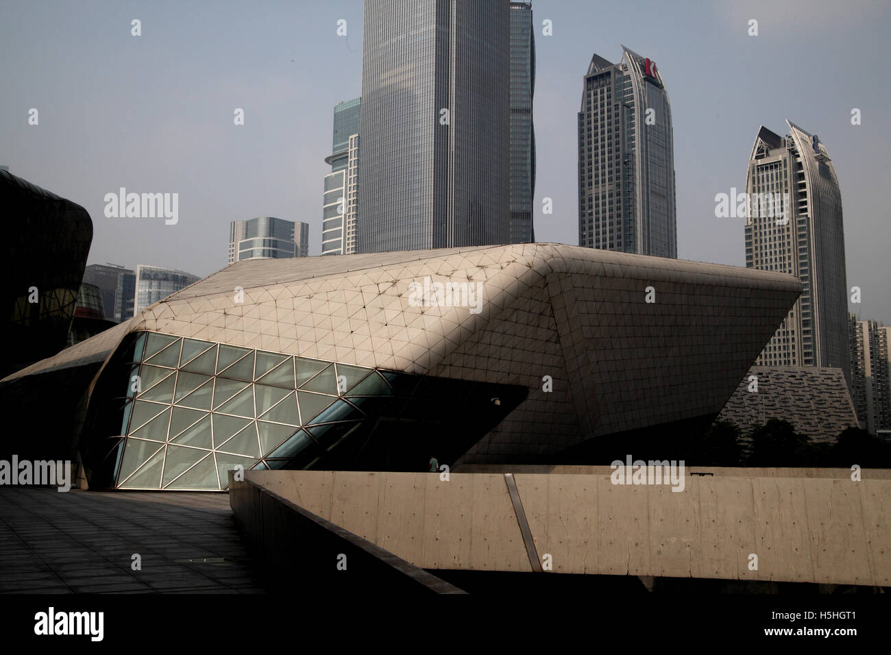 The top part of the Guangzhou Opera House designed by Zaha Hadid and three commercial high rise builldings behind it. Guangzhou. Stock Photo