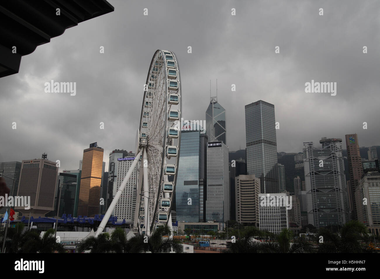 Unnamed giant wheel and the Hong Kong skyline, high rise commercial buildings, yellow on the left is the Far East Finance Centre Stock Photo