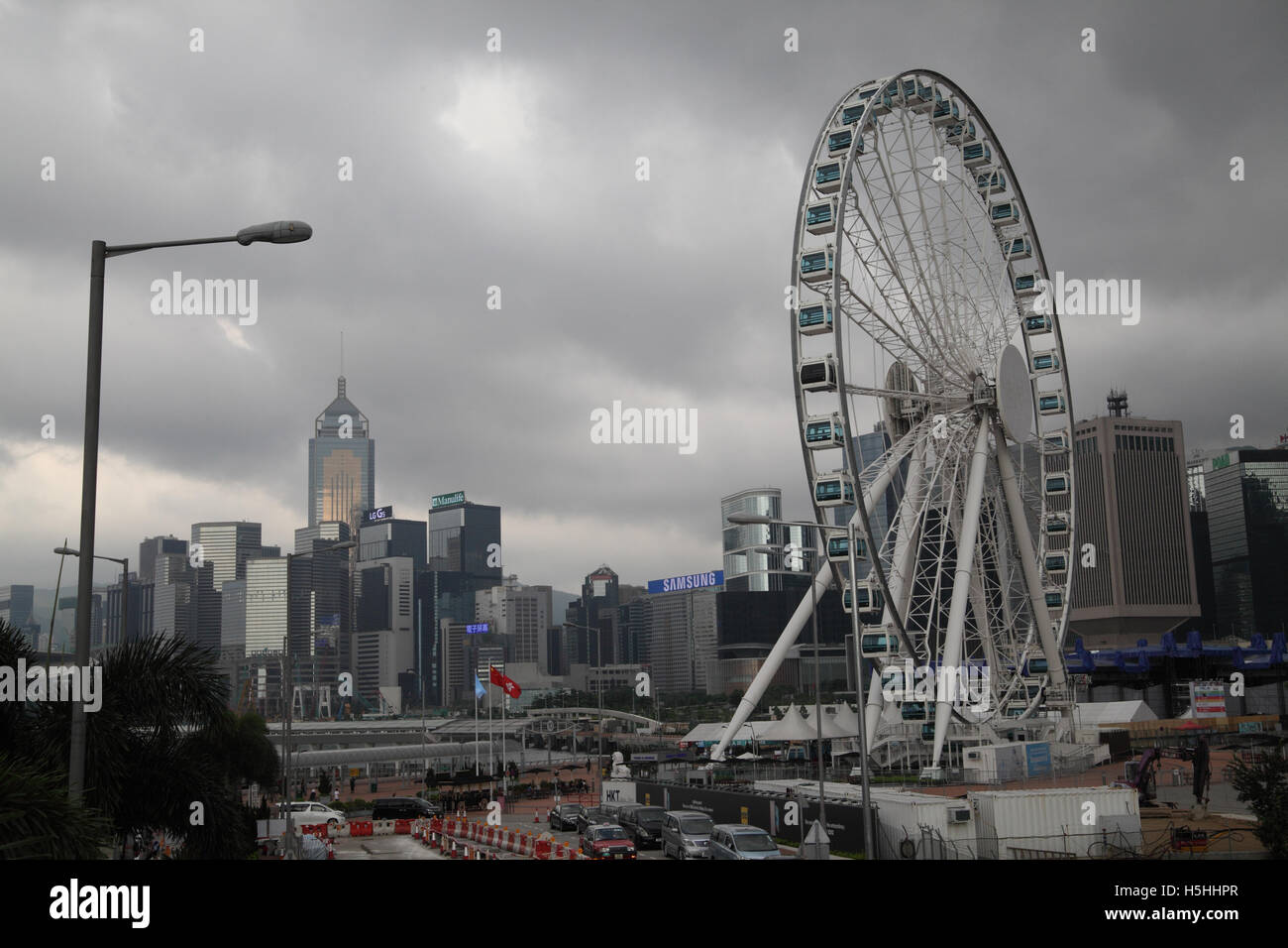 A yet unnamed giant wheel and the Hong Kong skyline of high rise commercial buildings, with the Central Plaza on the left Stock Photo