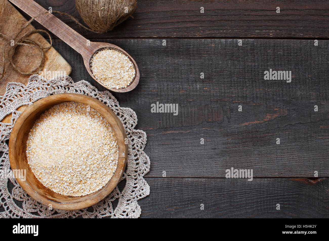 Oat bran in the wooden bowl on the dark table Stock Photo