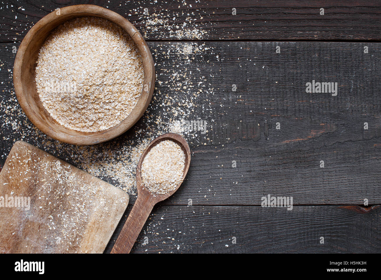 Oat bran in the wooden bowl on the dark table Stock Photo