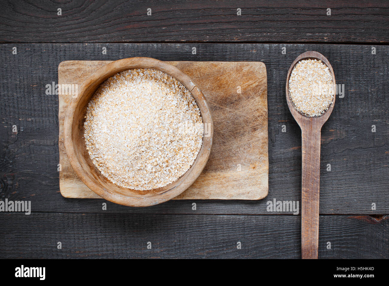 Oat bran in the wooden bowl on the dark table Stock Photo