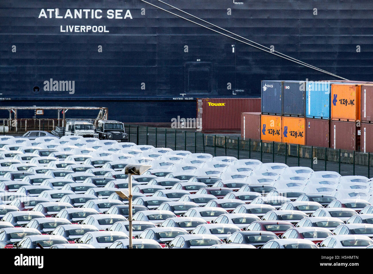 Cars waiting to be loaded at dock; New Luxury British made cars under