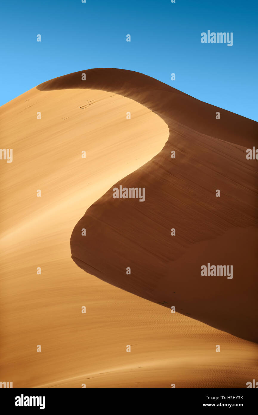 sand being blown on Sahara sand dunes of erg Chebbi, Merzouga Morocco, Africa Stock Photo