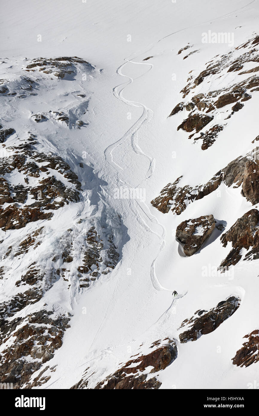 Snowboard freeriding between the rocks in Alps. Extreme winter sports. Stock Photo