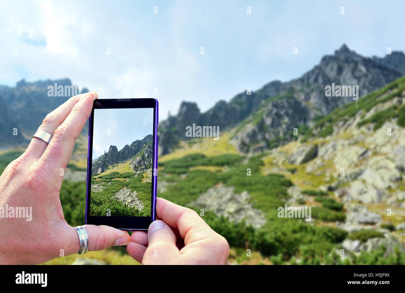 View over the mobile phone display during taking a picture of landscape in nature. Holding the mobile phone in hands and taking Stock Photo
