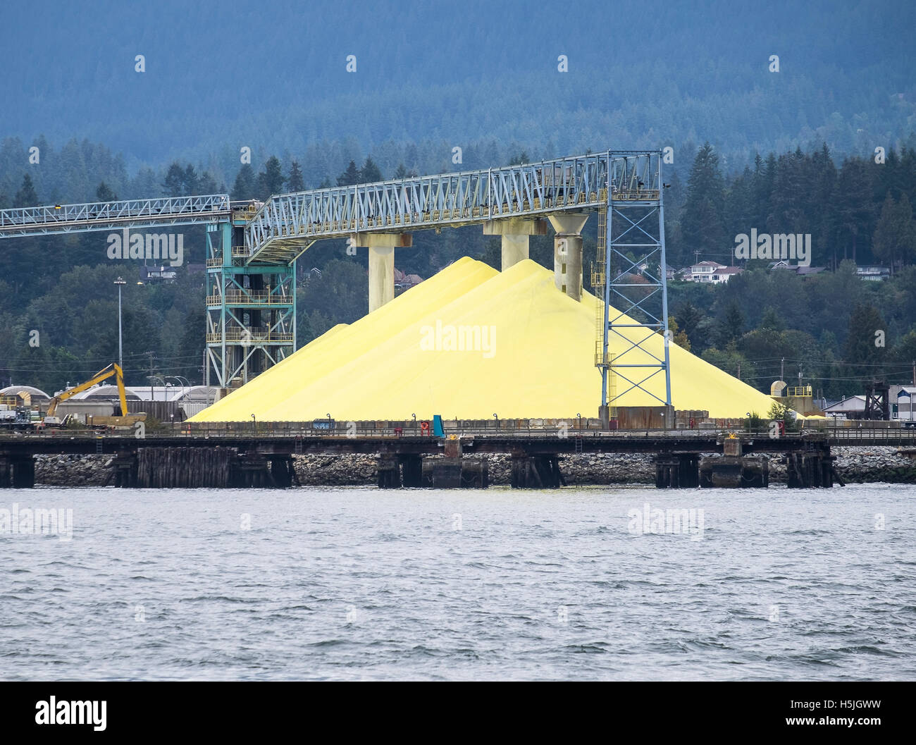 A large pile of sulphur powder stockpiled at a depot in ready for use.  Vancouver British Columbia Canada. Stock Photo