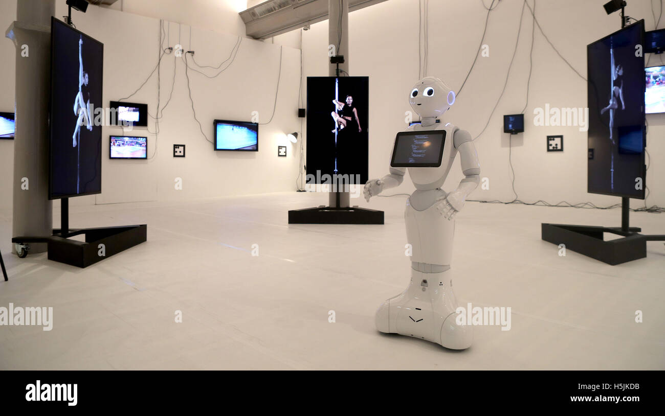 London-based artist Cecile B. Evans' 'Sprung a Leak 2016', a multi-dimensional work featuring two humanoid robots and a robot dog who communicate with human performers present in the space via monitors, held at Tate Liverpool from Friday October 21 - Sunday March 19. Stock Photo