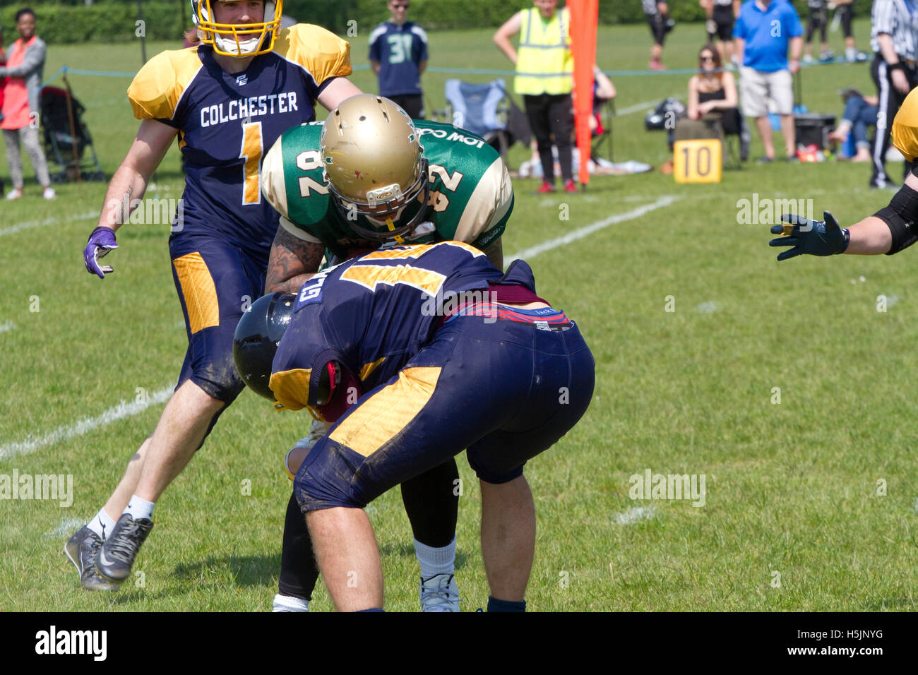 Odd bent over tackle in a British American football game Stock Photo