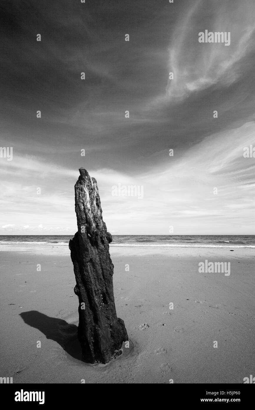 Old wooden post on Brancaster beach, Norfolk, UK. Stock Photo