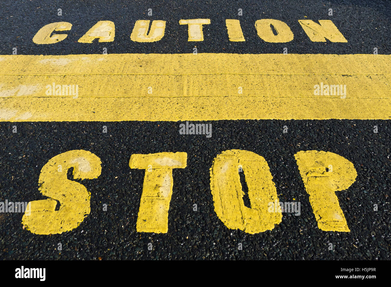 CAUTION STOP painted onto the road. Stock Photo