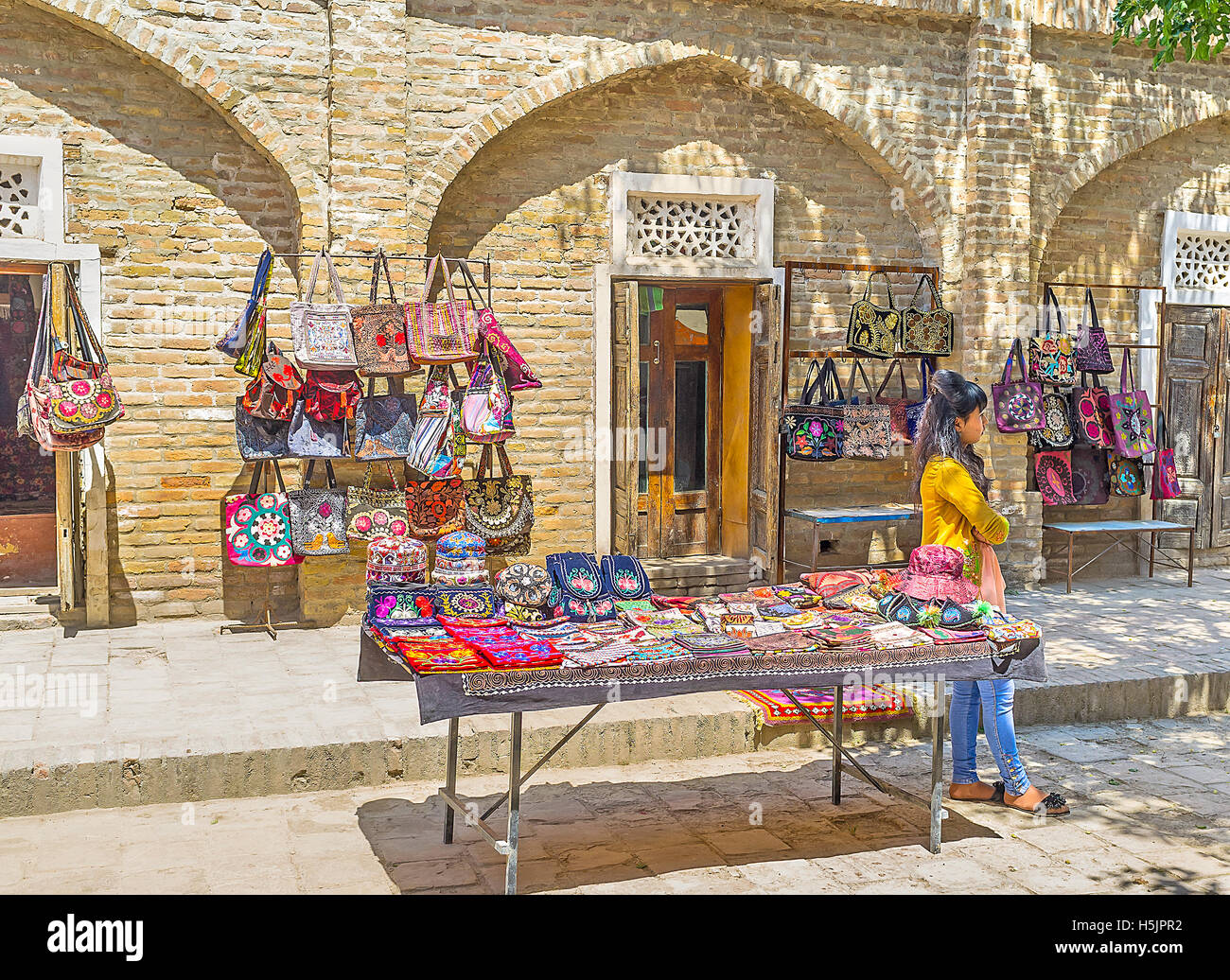 The stall with the handmade colored bags, decorated with the floral embroideries Stock Photo