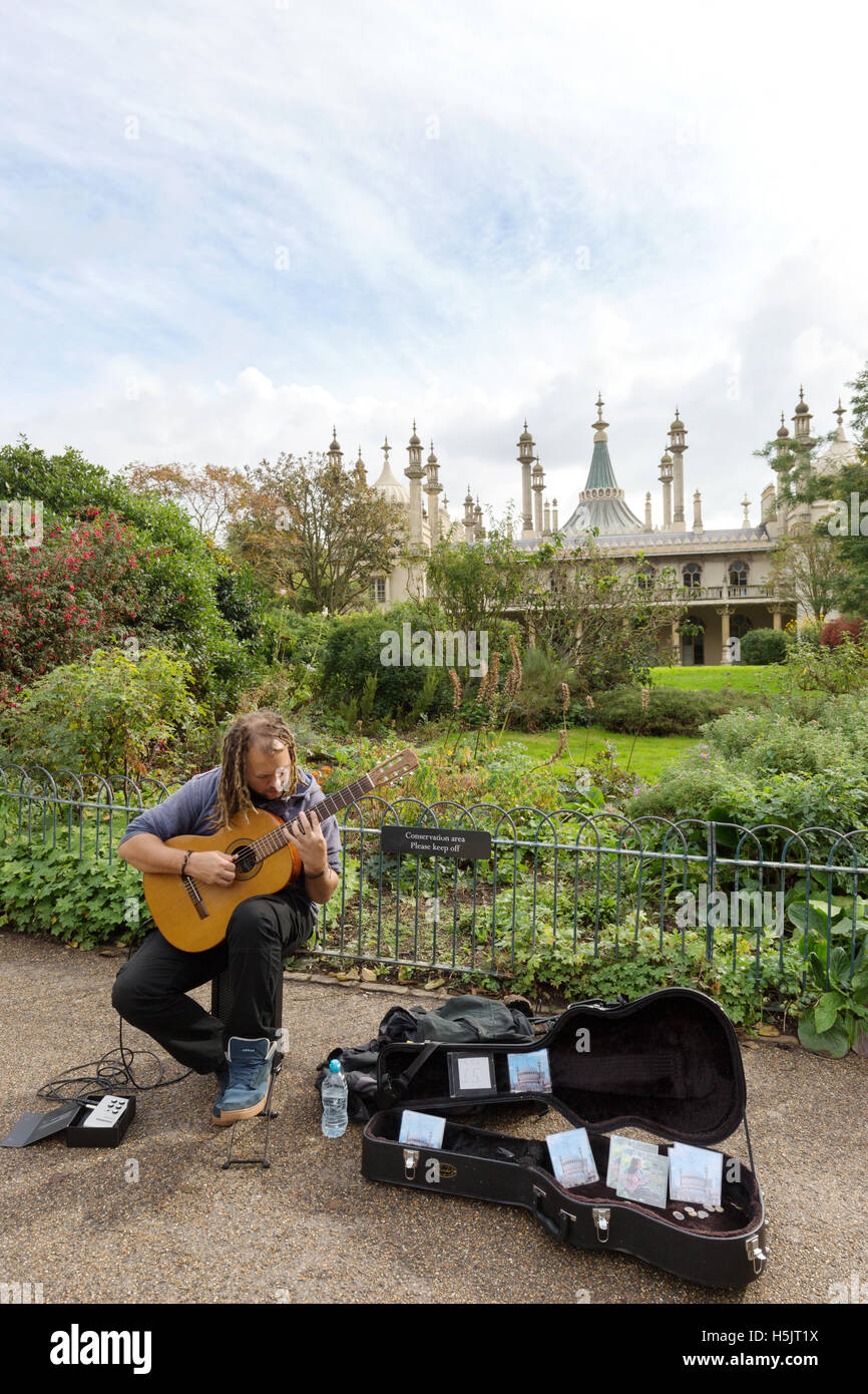 A busker playing guitar in front of the Brighton Royal Pavilion, Brighton, East Sussex England UK Stock Photo