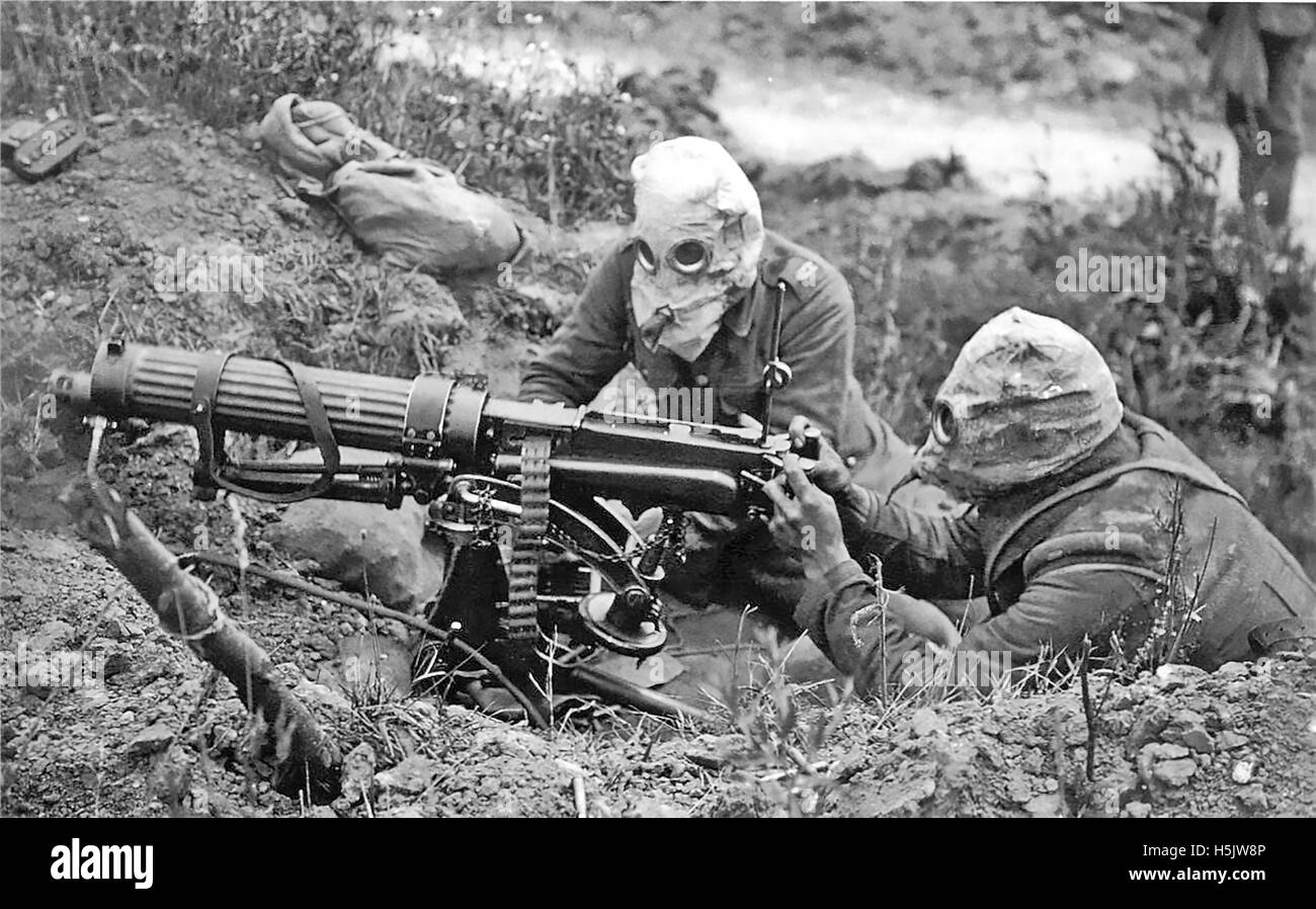 MACHINE GUN CORPS First World War. Two man gun crew (loader and firer) wearing early PH-type gas helmets using a Vickers Mk 1 water-cooled machine gun  in a dugout near Ovillers in July 1916 during the Battle of the Somme. Stock Photo