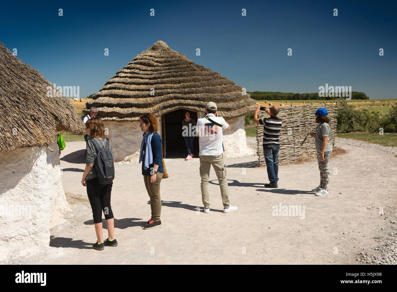 UK, England, Wiltshire, Stonehenge Visitor Centre visitors in reconstructed Neolithic village Stock Photo